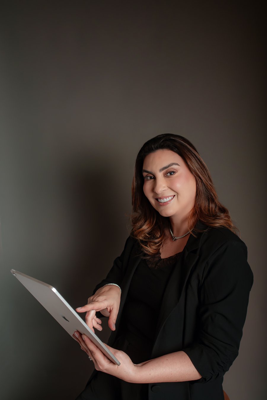 Monica Caldas consultando um tablet durante a avaliação